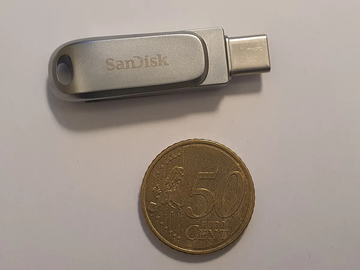 Chiavetta USB USB-C appoggiata su un tavolo accanto a una moneta, close up della memoria flash che il computer non riconosce più