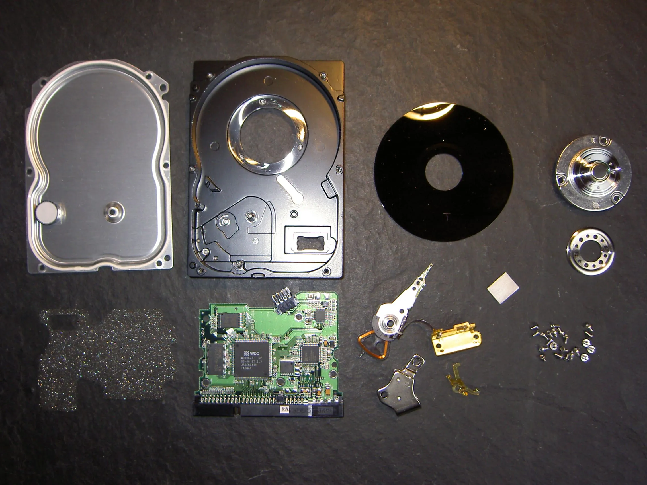 Hard disk meccanico aperto con piatti magnetici e testine visibili