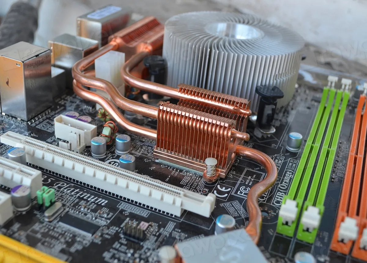 Scheda madre di un computer fisso con dissipatore e slot RAM, la diagnosi hardware quando il PC non si accende
